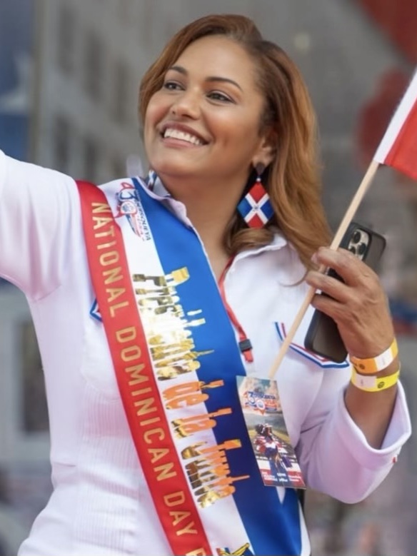 Woman wearing a Dominican Day sash at a community event
